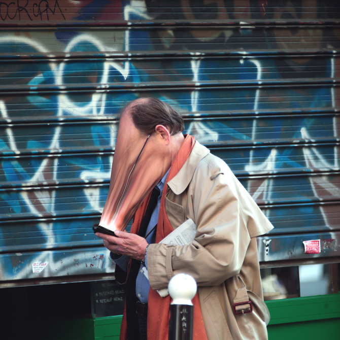 man looking into cell phone with face stretched appearing to be sucked into or glued onto the screen